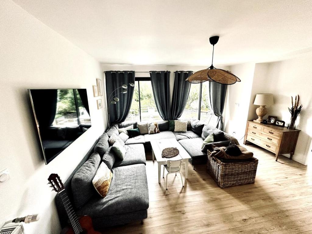 una sala de estar con un sofá y una mesa en Charming beach house, Les Embruns, en Hermanville-sur-Mer