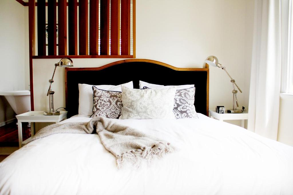 a bedroom with a white bed with white sheets and pillows at Hosking House in New Plymouth