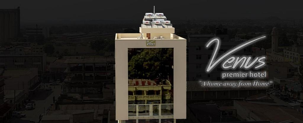 Un palazzo alto con un cartello sopra. di Venus Premier Hotel ad Arusha