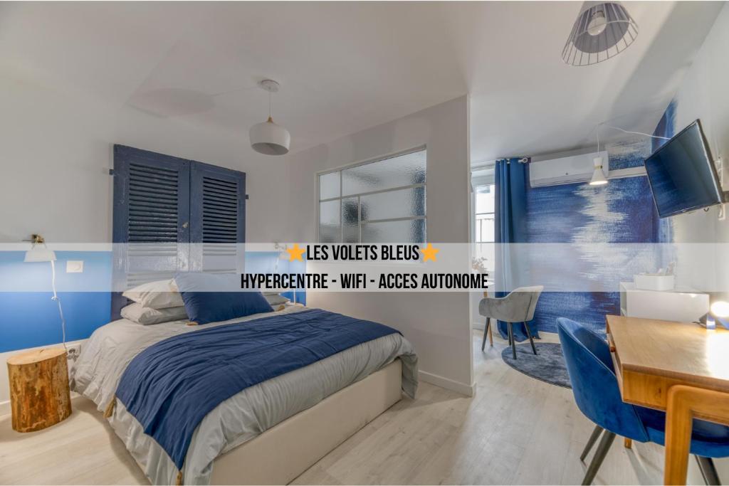 a bedroom with a bed and a desk and a table at Les Volets Bleus - Centre ville - WIFI by CLÉ HÔTES in Saint-Vallier