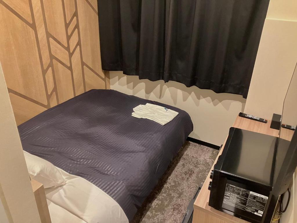 Postel nebo postele na pokoji v ubytování HOTEL LiVEMAX Mihara Ekimae