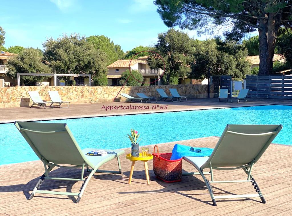 deux chaises et une table à côté d'une piscine dans l'établissement Appart Cala Rossa - Porto-Vecchio - Mer à pied, à Lecci