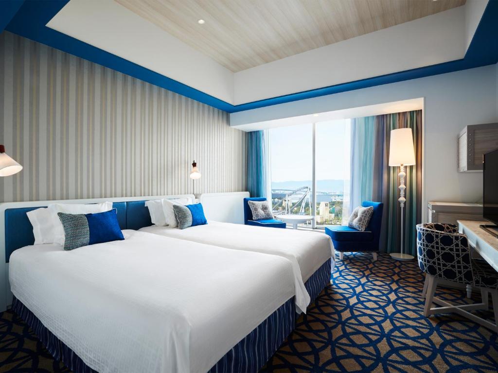 a large white bed in a room with a large window at Hotel Universal Port in Osaka