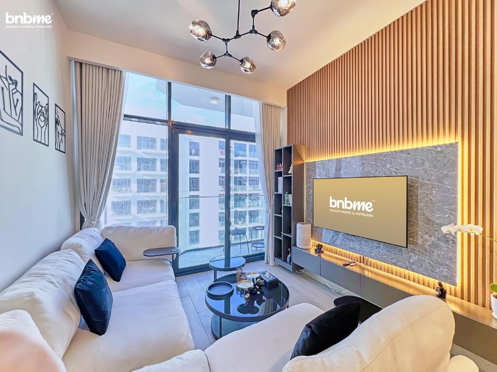 a living room with a couch and a tv at bnbmehomes - Azizi Riviera 45 in Dubai