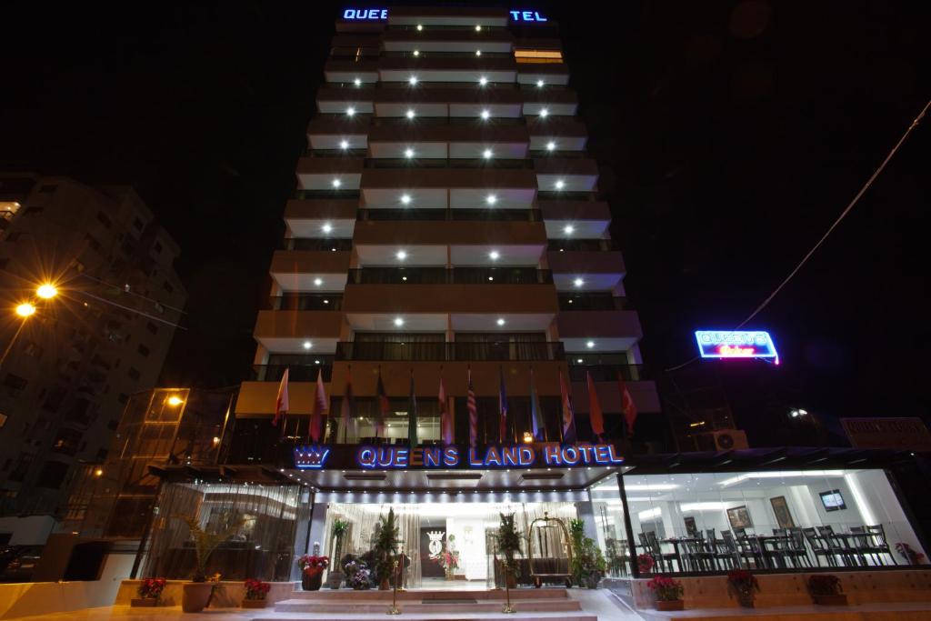 un edificio con un letrero que lee uno de nosotros el hotel en Queens Land Hotel, en Jounieh