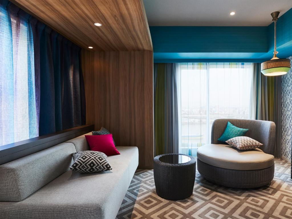 a living room with a couch and a chair at Hotel Universal Port in Osaka