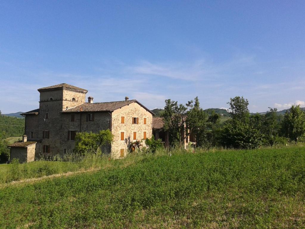 an old house on a hill in a field at Agriturismo Ca' Bertu' in Zappolino