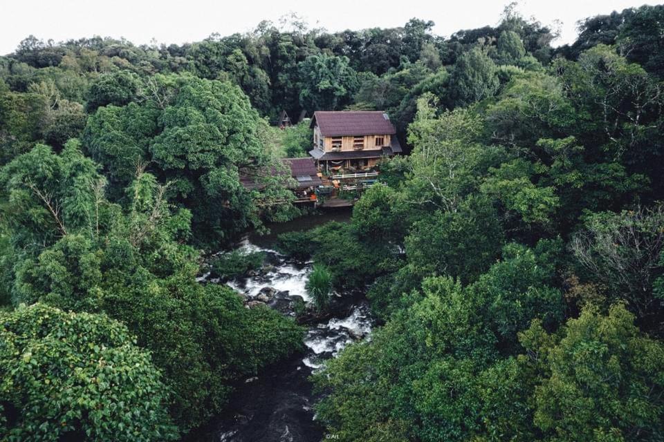 a house sitting on a bridge over a river at De Lueb Domitory in Ban Houayman