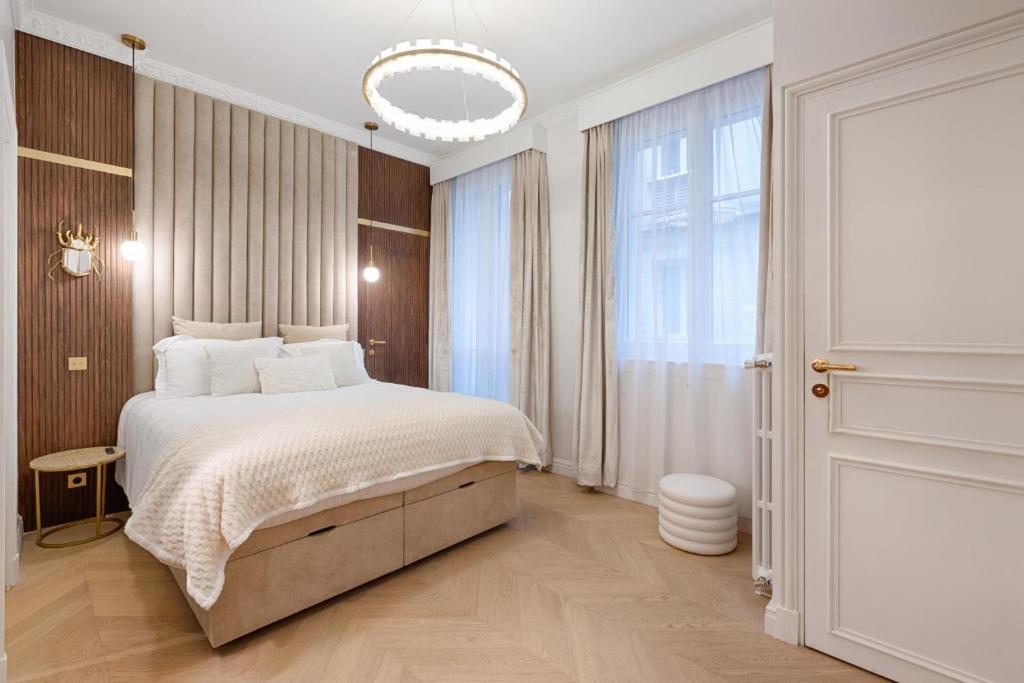une chambre avec un grand lit et une grande fenêtre dans l'établissement Avenue des Champs-Elysées, Appartement d’exception, à Paris