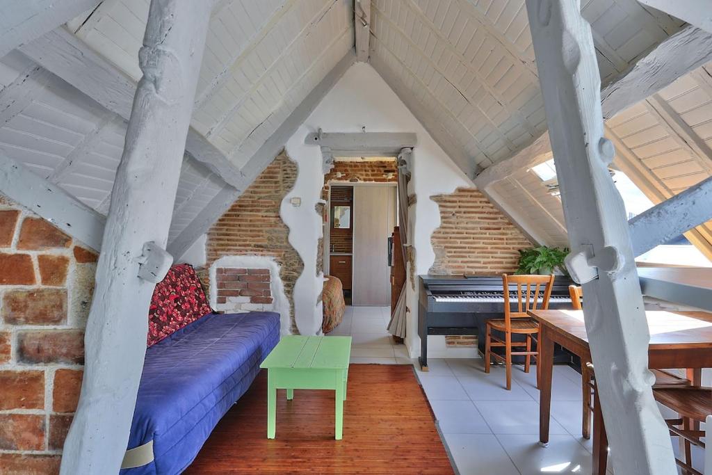 - un salon avec un lit et un piano dans l'établissement T1 bis charmant Place Graslin, à Nantes