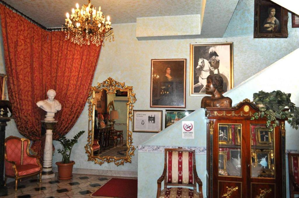 a living room filled with furniture and a mirror at Hotel Giulietta e Romeo in Casal Palocco