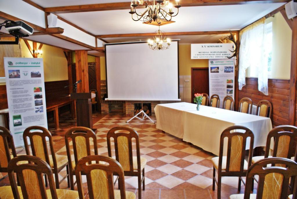 Conference room with chairs, projector screen, and informational posters.