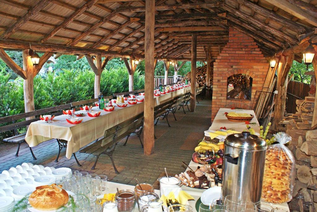 Rustic outdoor dining setup with long tables and buffet spread.