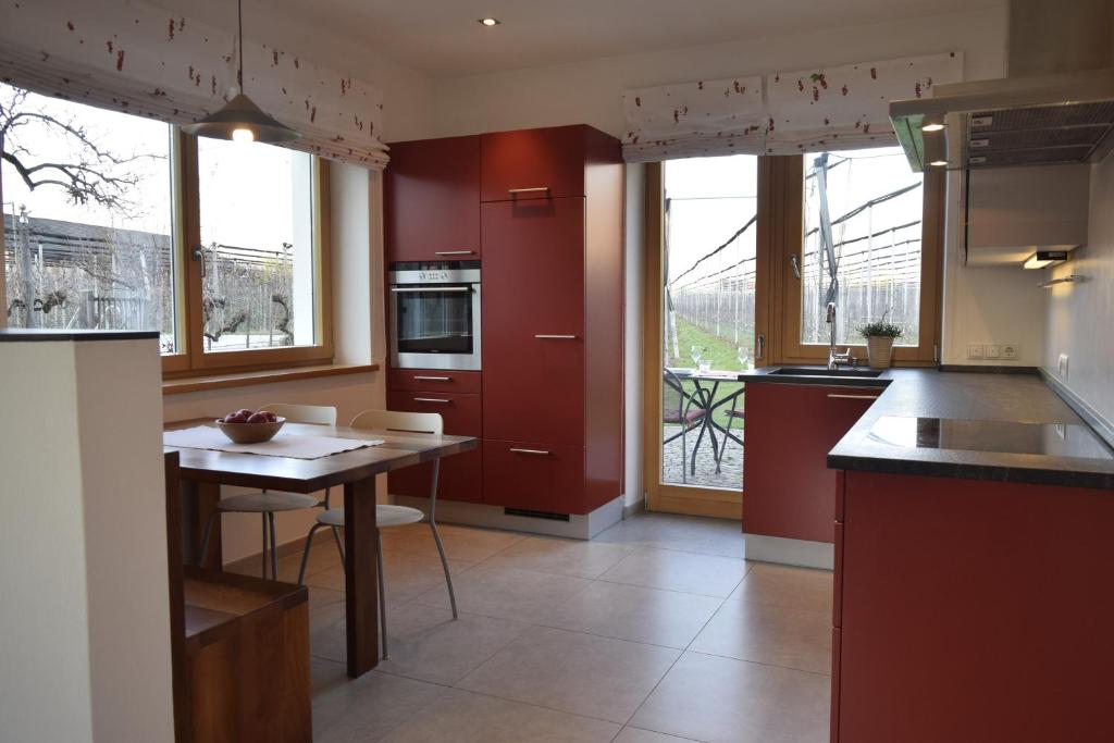 a kitchen with red cabinets and a table in it at Appartment Gut Wendlandt in Bolzano