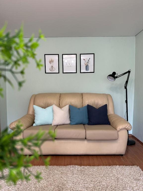 Una sala de estar con un sofá con almohadas. en Лободы 34 красиво и уютно, en Karagandá