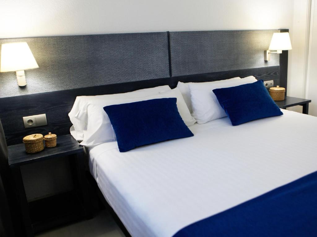 a hotel room with two beds and two lamps at Acacias Apartamentos Salou in Salou