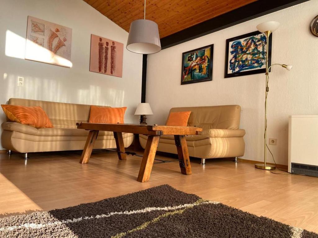 a living room with two couches and a table at Ferienhäuser Fedderwardersiel Am Yachthafen 92 in Fedderwarderdeich