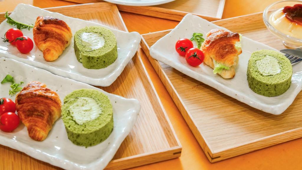 three plates of food with croissants and tomatoes on a table at 熱海山荘 in Atami