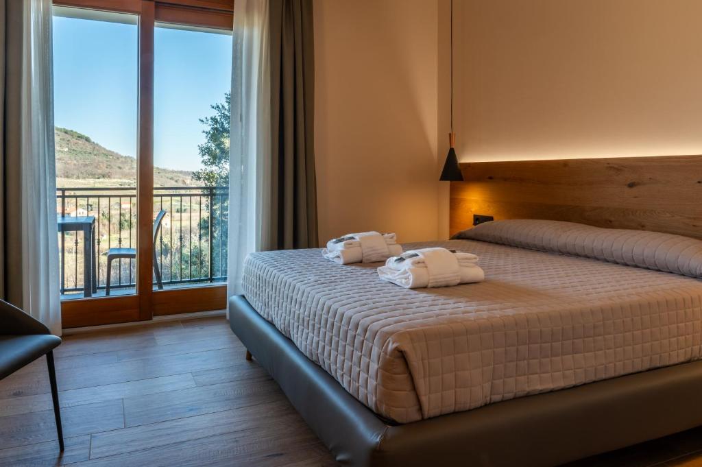 Postel nebo postele na pokoji v ubytování AURA Dimore ad Arquà Petrarca