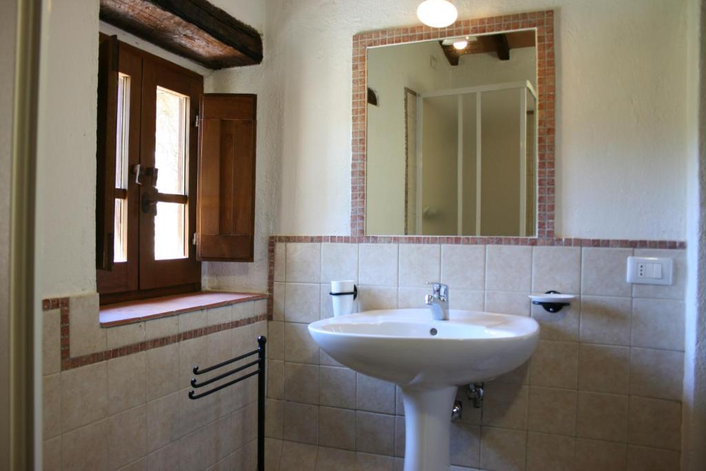 une salle de bain avec un lavabo et un miroir dans l'établissement Borgo Antico, à Poggioni 27 autres photos