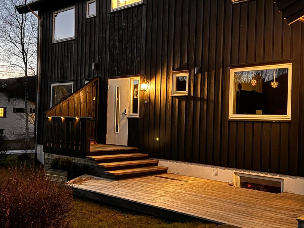 a house with a wooden porch and stairs on it at Ustedalen Lodge in Geilo