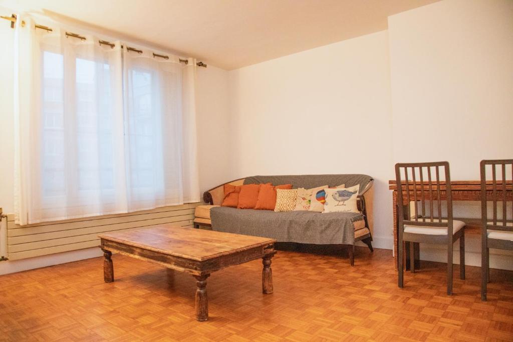 una sala de estar con un sofá y una mesa en 2 bedrooms 60m2 near RER A, en Joinville-le-Pont