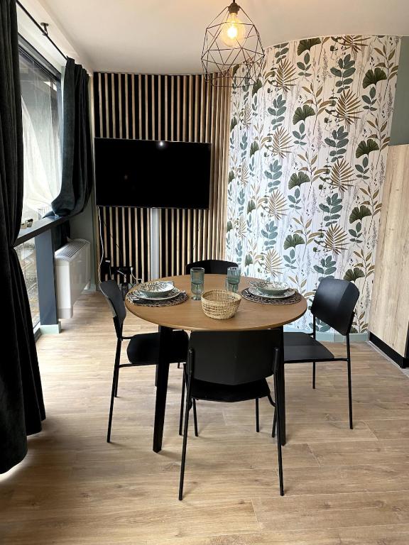 une salle à manger avec une table, des chaises et une télévision dans l'établissement Écrin Vitré en Plein Toulouse, à Toulouse
