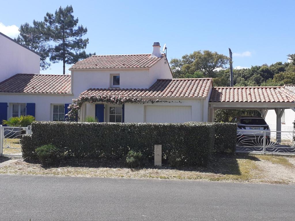 une maison blanche avec une voiture garée devant elle dans l'établissement Villa proche forêt et plage à La Tranche-sur-Mer - FR-1-22-381, à La Tranche-sur-Mer