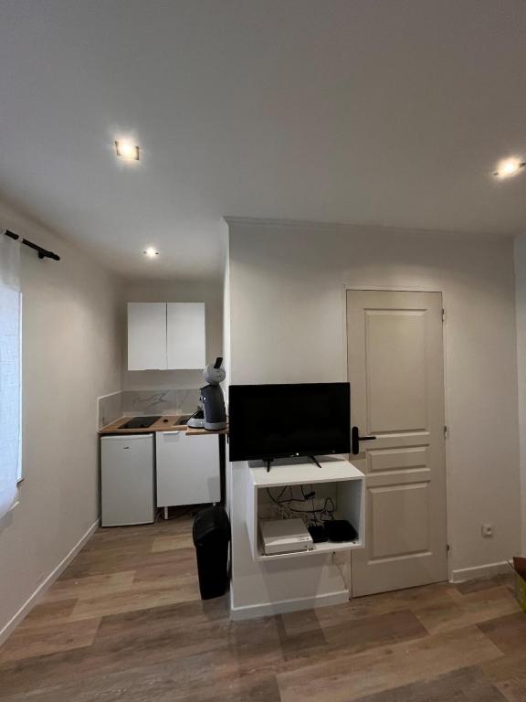 - une cuisine avec un bureau et un moniteur dans l'établissement joli petit studio, à Mantes-la-Jolie