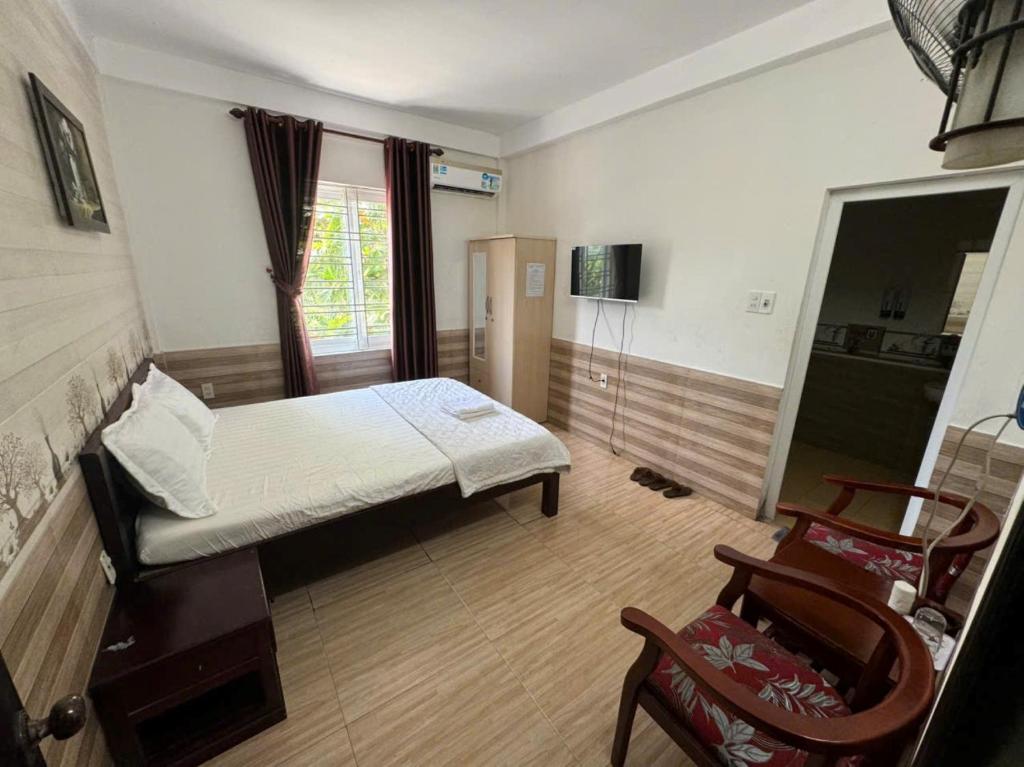 une chambre avec un lit et une chaise dedans dans l'établissement Trường Ân Homestay, à Hue