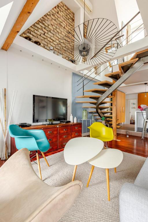 un salon avec une table et des chaises et un escalier dans l'établissement Superbe duplex prox centre-ville Beautiful duplex close to center, à Strasbourg