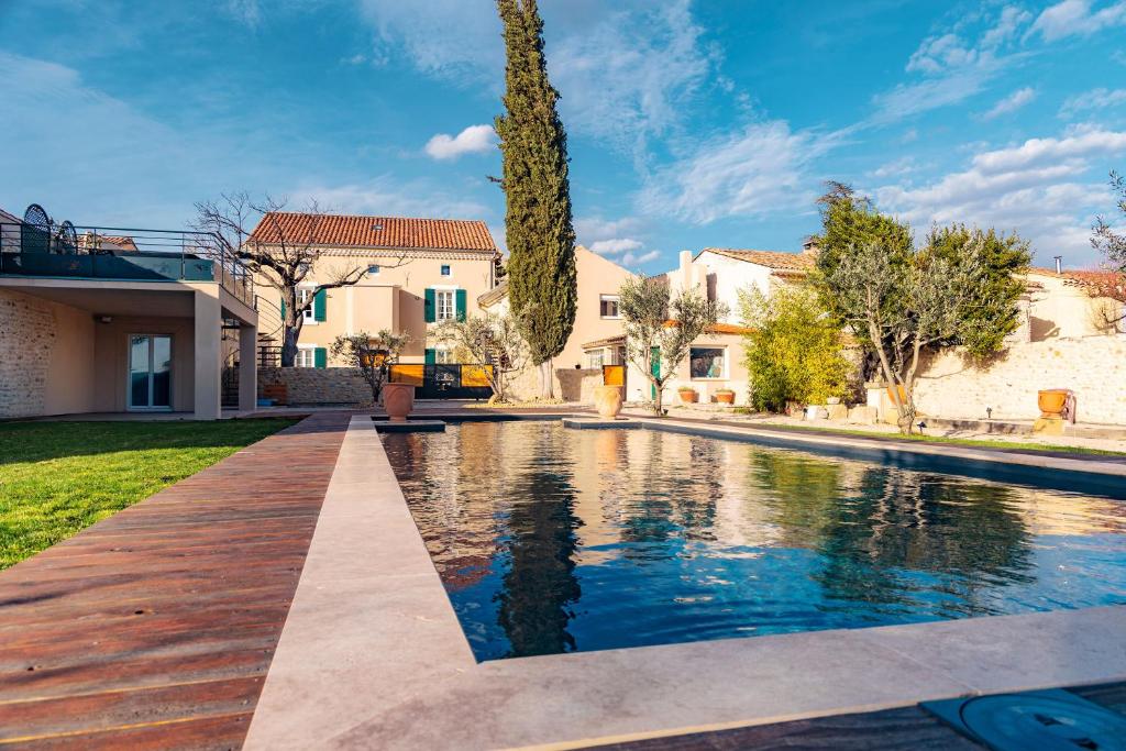 a swimming pool in the yard of a house at Le gîte du Haut de la Sousto in Rasteau