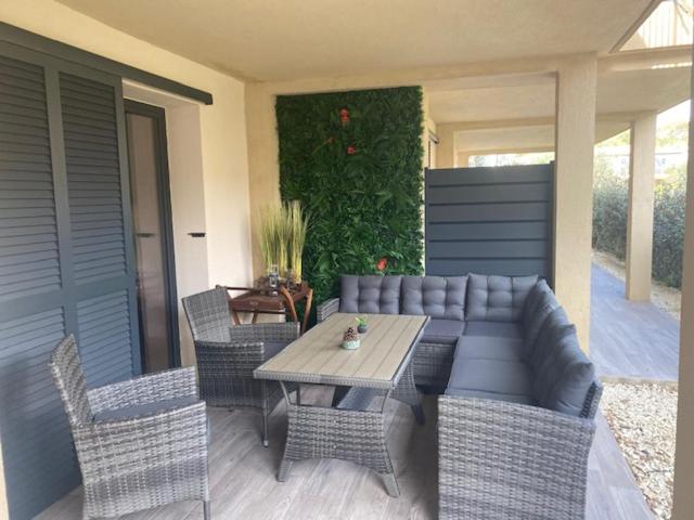 d'une terrasse avec une table et des chaises en osier. dans l'établissement villa jérémy, à Bonifacio