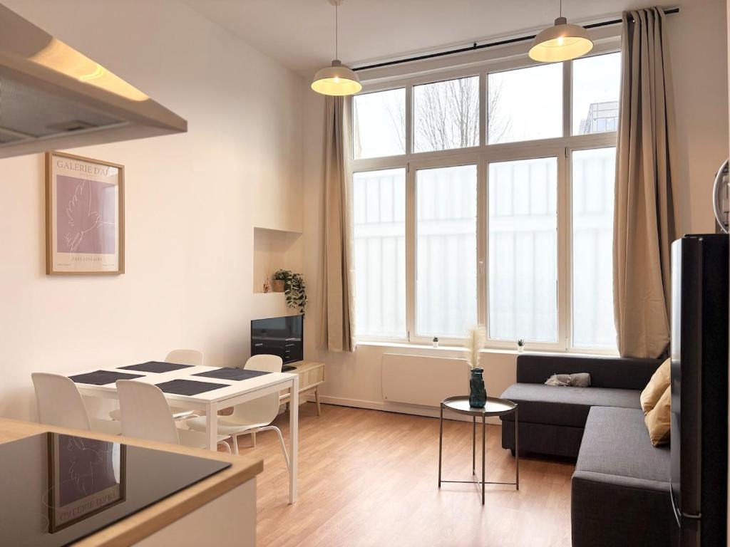 un salon avec une table et une salle à manger dans l'établissement Appartement 6 voyageurs - Roubaix, à Roubaix