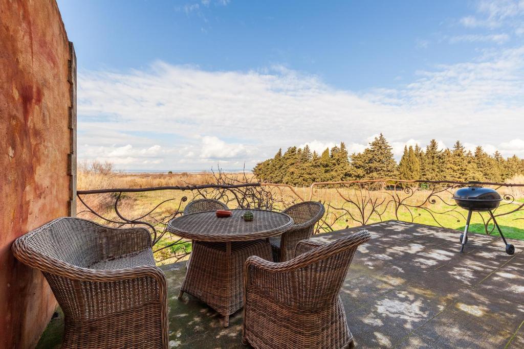 un patio avec une table, des chaises et un barbecue dans l'établissement A Pincu, Rural Et Atypique, à Châteauneuf-les-Martigues