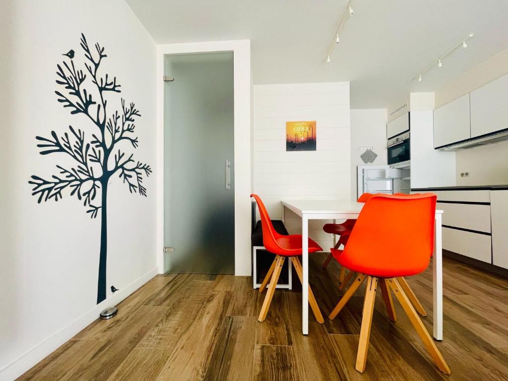eine Küche mit einem Tisch und 2 roten Stühlen in der Unterkunft Lamsoor 9A* in Nieuwvliet