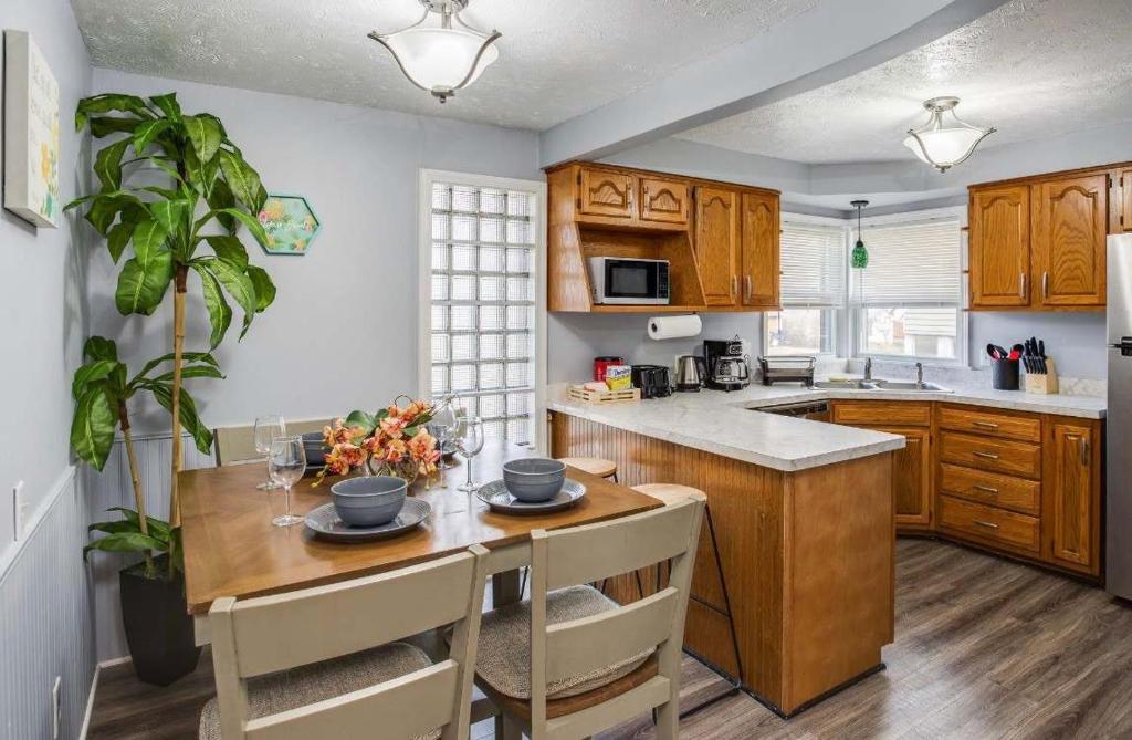 a kitchen with wooden cabinets and a wooden table with chairs at Astonishing Home Mins Away Airport Dwtn UofR andRIT in Rochester