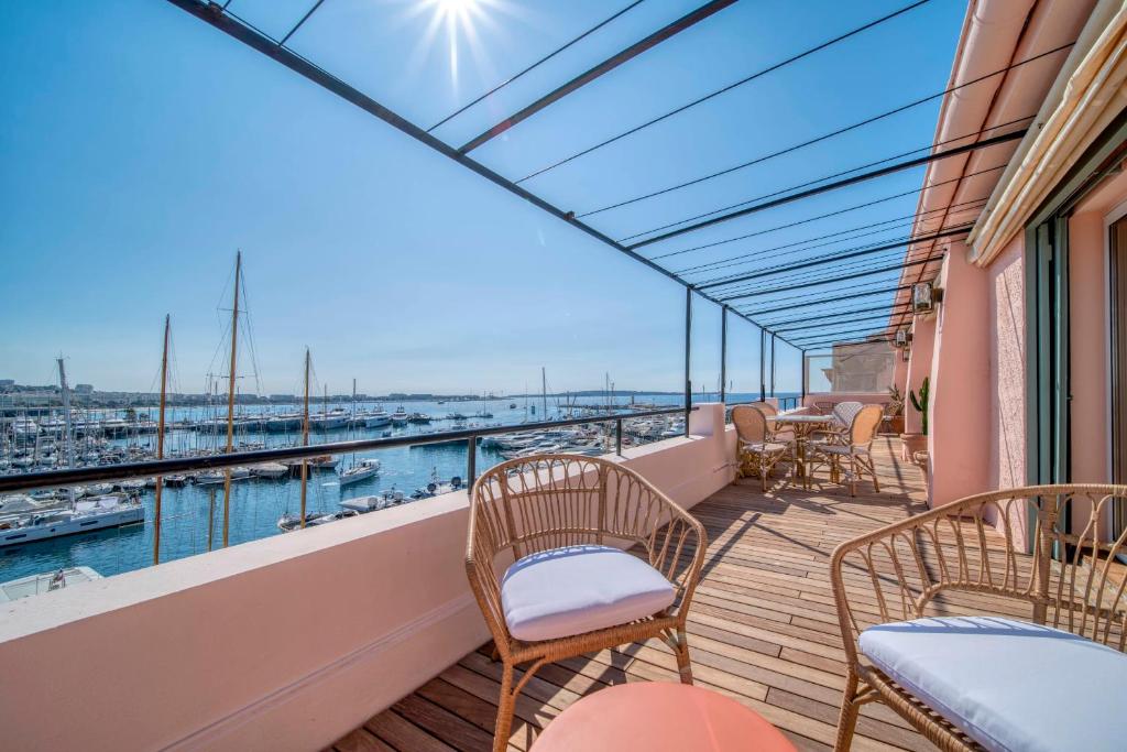 d'un balcon avec des chaises et des tables offrant une vue sur l'eau. dans l'établissement REF 1923 - Cannes Old Port - Sea view apartment for rent, à Cannes