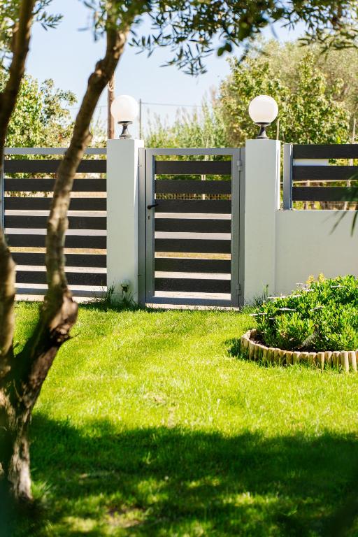 a fence with a gate in a yard at Oasis Houses Maggana ,Xanthi in Mángana