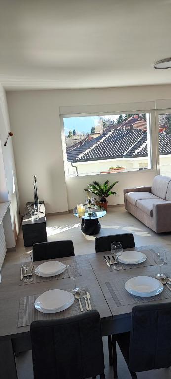 a dining room with a table and chairs and a couch at Tominettihome in Verbania