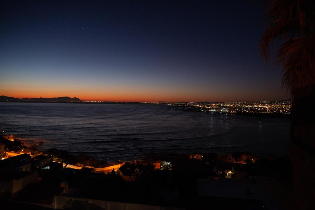 a view of the ocean at night at View Panoramica Self-Catering Apartment in Gordonʼs Bay