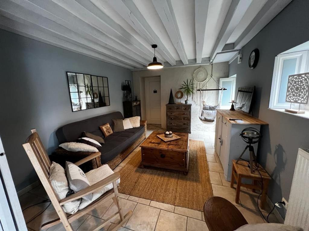 ein Wohnzimmer mit Sofa und Tisch in der Unterkunft Charmante maison proche des châteaux de Loire in Baule