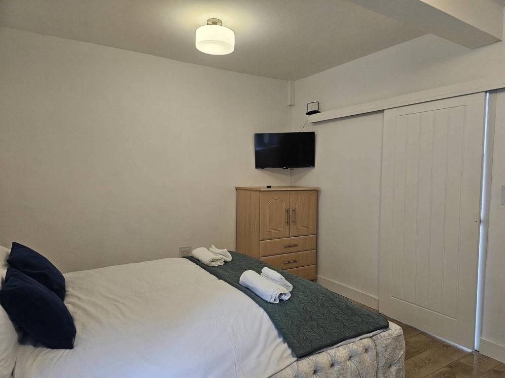 a bedroom with a bed and a flat screen tv at Studio - Sleeps 2 - Parking - WiFi in Bridgend