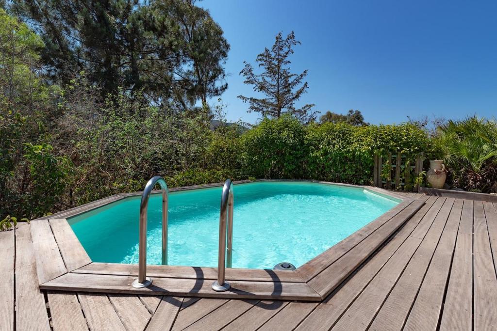 - une piscine sur une terrasse en bois dans l'établissement Le Maquis, Véritable havre de paix sur les hauteurs d'Ajaccio, à Alata