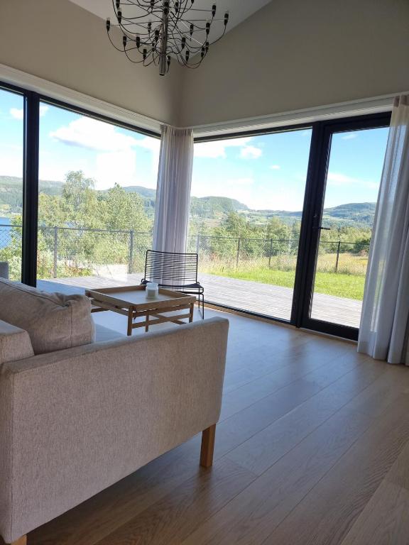 a living room with a couch and large windows at Seaside Holiday Home in Hjelmeland