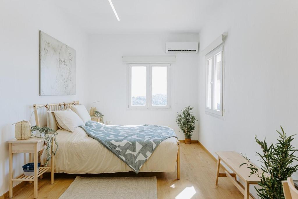 Un dormitorio blanco con una cama y dos ventanas. en Stylish Stonehouse in Platres, en Platres