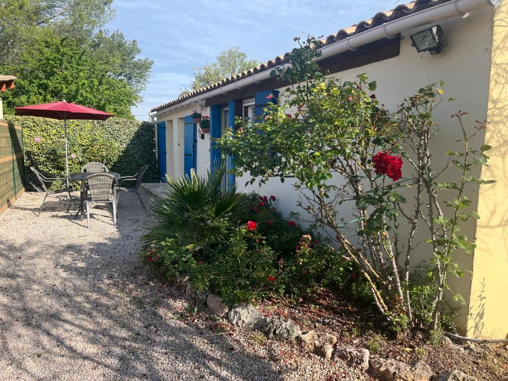 une petite maison avec une table et un parasol dans l'établissement La maison aux volets bleus, à Draguignan