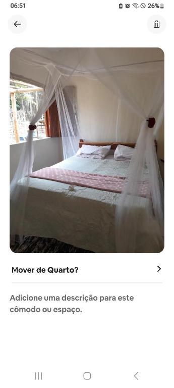 a bedroom with a white bed with a canopy at Suíte afastada do Centro, na mata in Itacaré