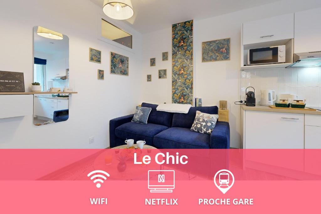 un salon avec un canapé bleu et une cuisine dans l'établissement expat renting - Le Chic - Netflix - Proche gare, à Toulouse