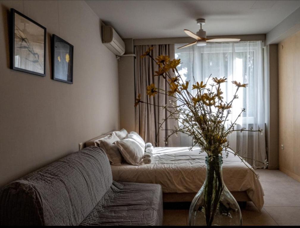 a living room with a couch and a vase with flowers at Downtown photographer's studio in Korinthos